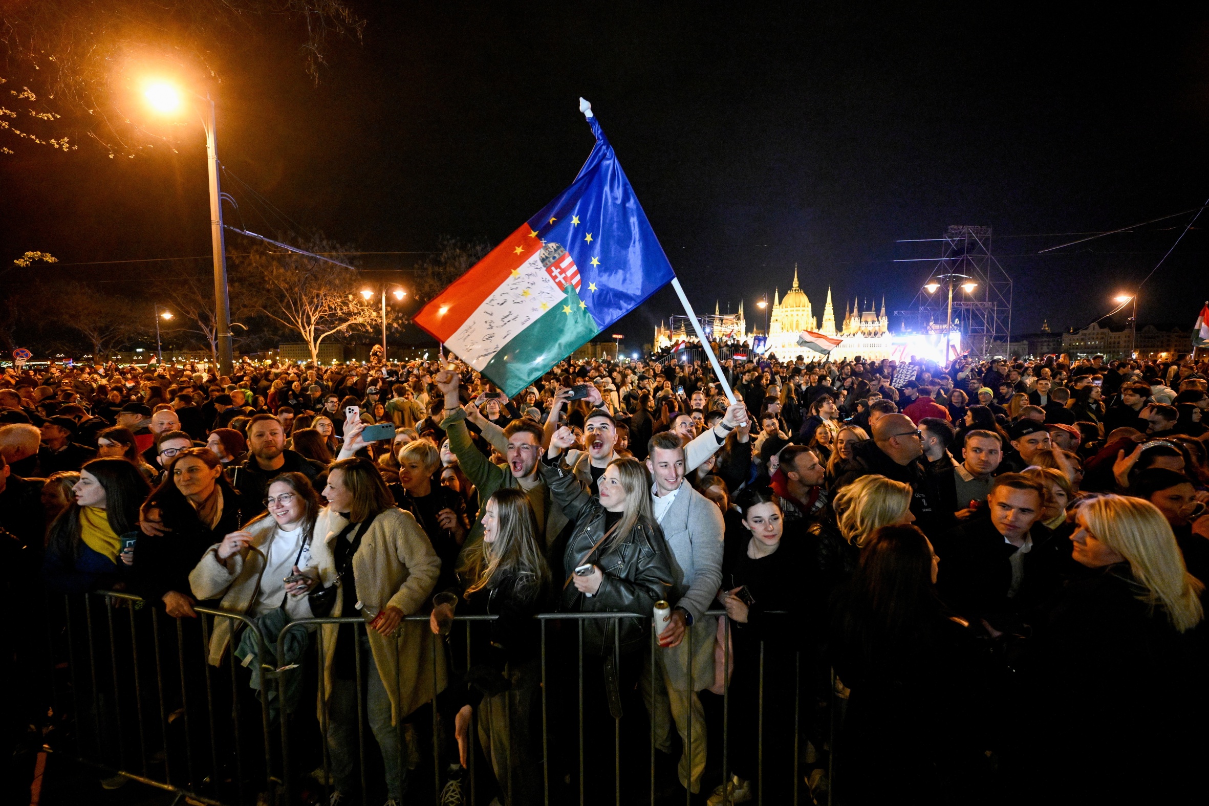Partidaris de Tisza, el partit de Péter Magyar, branden banderes d'Hongria i la UE abans-d'ahir a Budapest, durant la nit electoral (fotografia: Robert Hegedus/Efe).