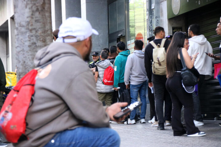 Una persona espera el seu torn a la cua amb cita prèvia de l'OAC per a la regularització en massa.