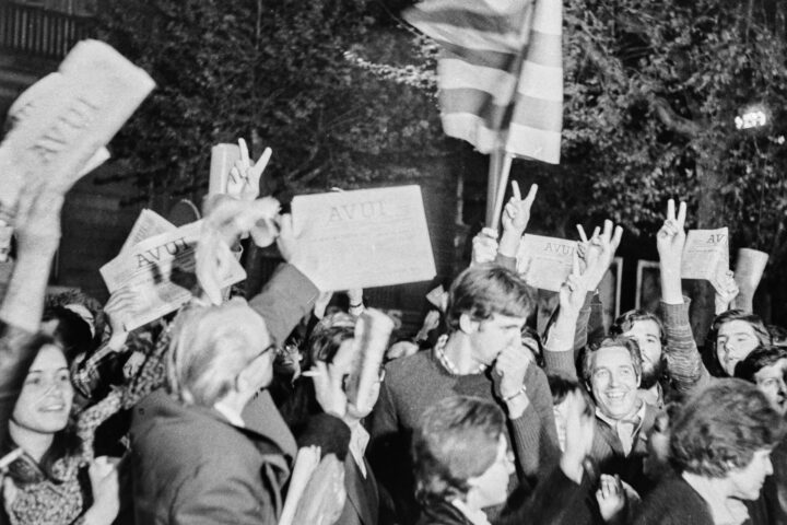 La gent oneja els primers exemplars del diari Avui la matinada del 23 d'Abril de 1976, al carrer Llúria de Barcelona, davant la rotativa del Ciero que feia servir el diari (Foto: Robert Ramos)
