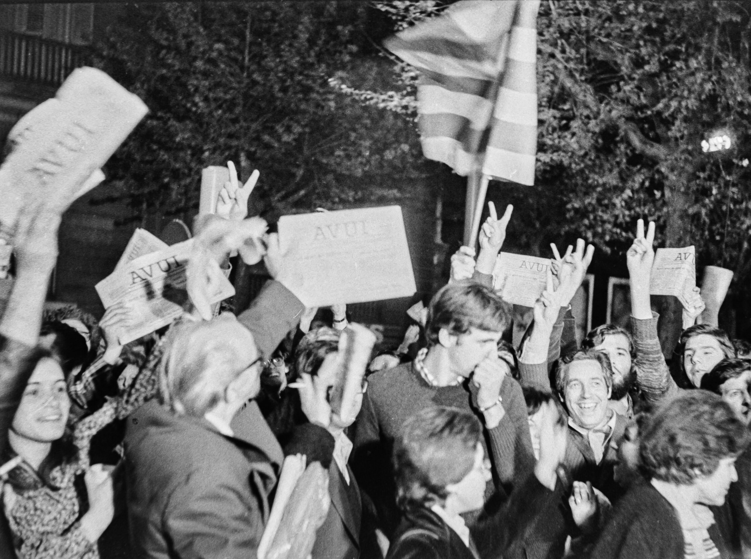 La gent oneja els primers exemplars del diari Avui la matinada del 23 d'Abril de 1976, al carrer Llúria de Barcelona, davant la rotativa del Ciero que feia servir el diari (Foto: Robert Ramos)