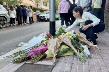 Una amiga de la dona assassinada a Esplugues de Llobregat posa flors al lloc on va morir (fotografia: ACN).