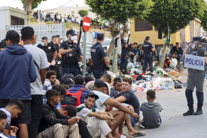 Immigrants i policia espanyola a les portes del centre d'acollida de Ceuta (fotografia: EFE / Reduan).