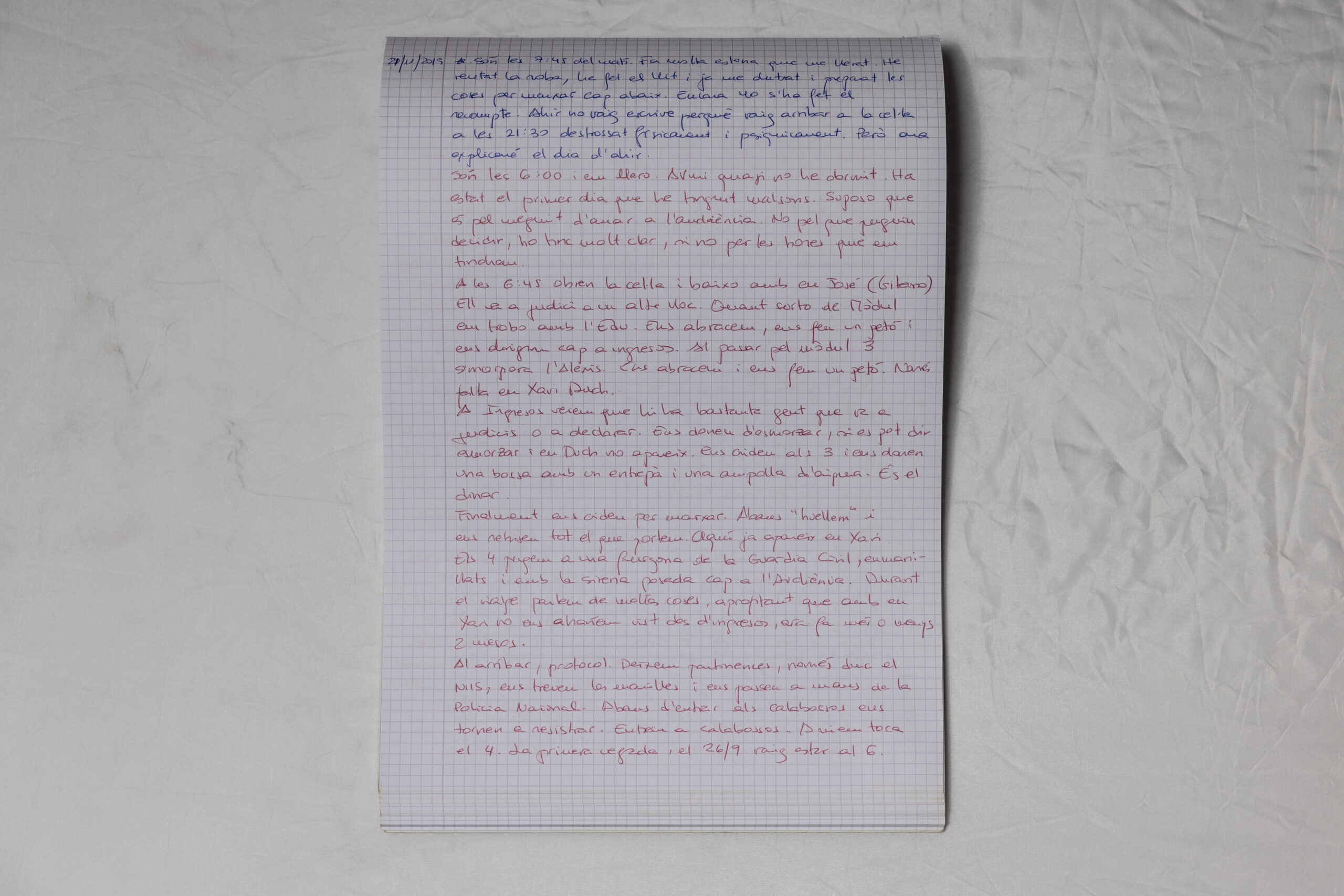 Full de llibreta quadriculada escrit a mà amb tinta blava i vermella